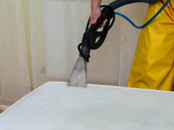 This is a photo of a man steam cleaning a dirty mattress works carried out by Penge Carpet Cleaning