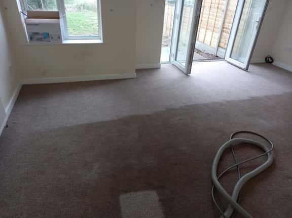This is a photo of an empty living room with a brown carpet that is in the process of having its carpets steam cleaned works carried out by Penge Carpet Cleaning