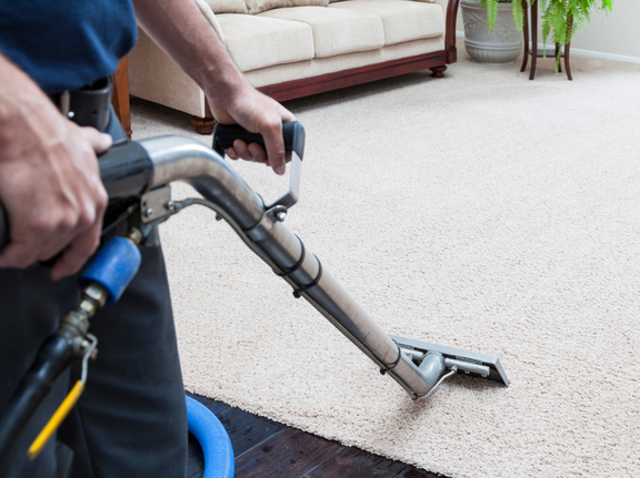 This is a photo of a man with a steam cleaner cleaning a cream carpet works carried out by Penge Carpet Cleaning